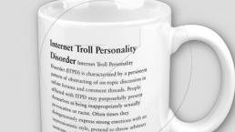 a cup inscribed with comments about trolls