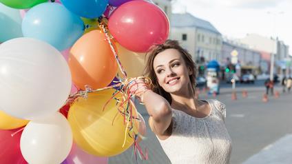 a woman holding balloons