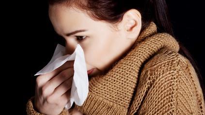 Image of a woman wiping nose wit a tissue