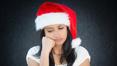 A girl with a Santa cap on her head and gloom on her face