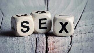 Word SEX inscribed on rolling dices