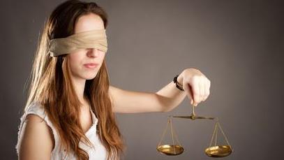 a blindfolded woman holding a balance