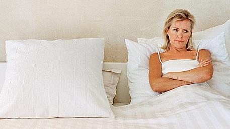 a woman sitting in her bed alone