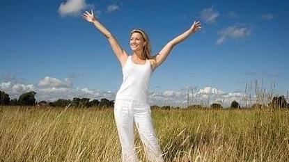 a woman in a field with her arms stretched out