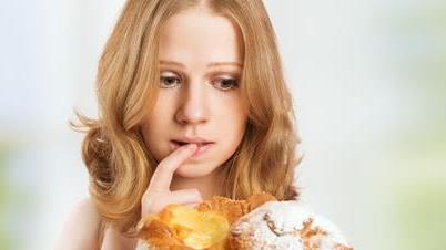 a woman looking worriedly at muffins