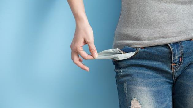 woman in blue jeans holding out empty pockets