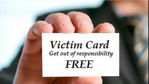 a man displaying a card inscribed with word 'victim card'