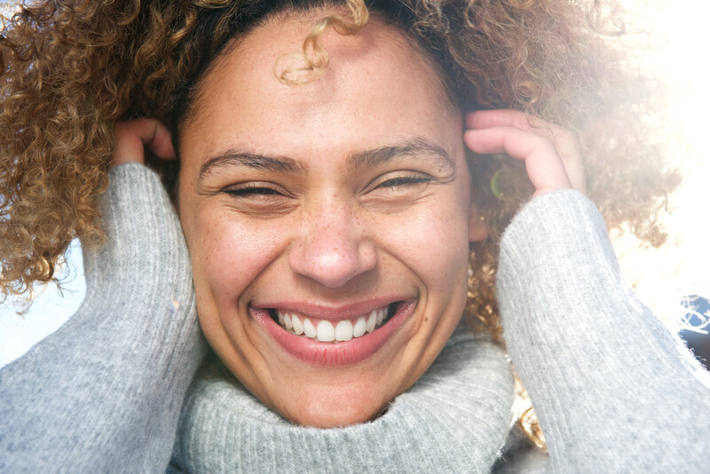 beautiful, smiling black woman in turtle neck sweater