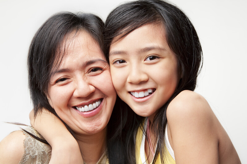 asian mother and child hugging and smiling