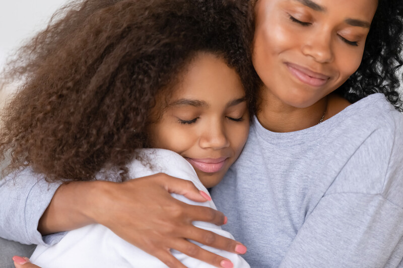 African american mother hugging her daughter