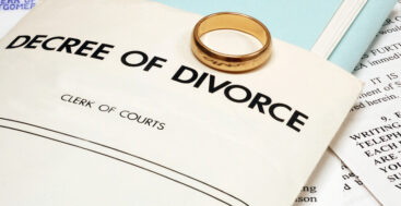 paper divorce decree with wedding ring on top