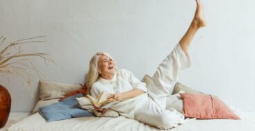 gray haired woman in bed kicking her legs up