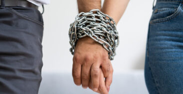 man and woman chained together at the wrists
